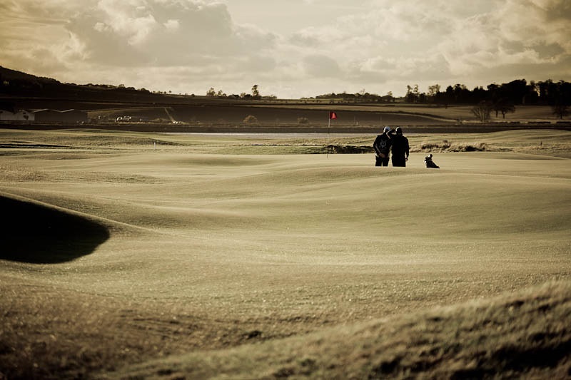 Two golfers line up a putt at St Andrews golf links